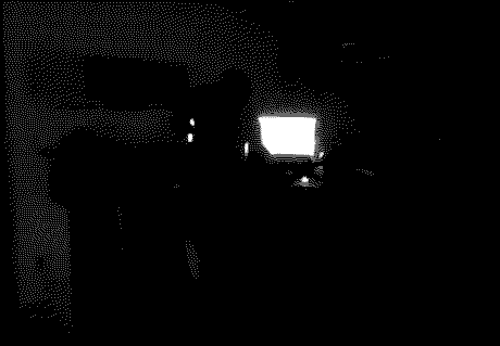 a black and white image with heavy dithering, you can make out two glowing computer screens and the vague outline of me reaching towards the table for a barely visible drum machine